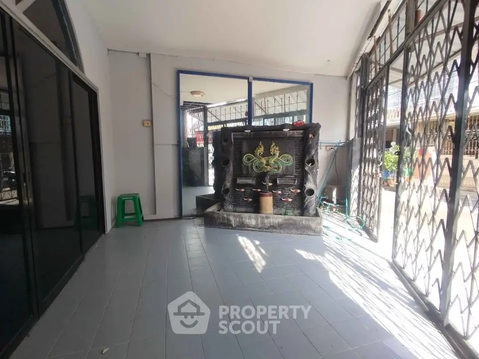 Spacious entrance area with decorative water feature and ample natural light.