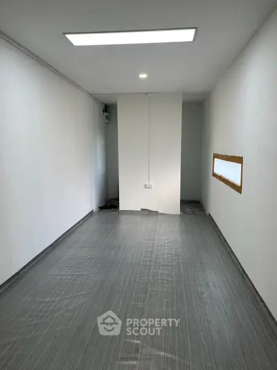 Minimalist interior space with modern flooring and recessed lighting, ideal for customization.