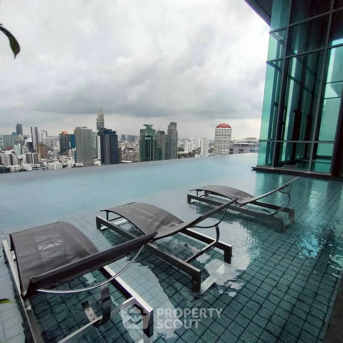 Luxurious rooftop infinity pool with stunning city skyline view, perfect for urban living enthusiasts.