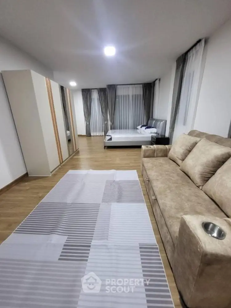 Spacious bedroom with modern decor and cozy seating area, perfect for relaxation.
