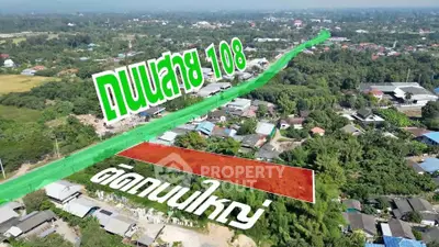 Aerial view of a large plot of land adjacent to a major road, ideal for development.