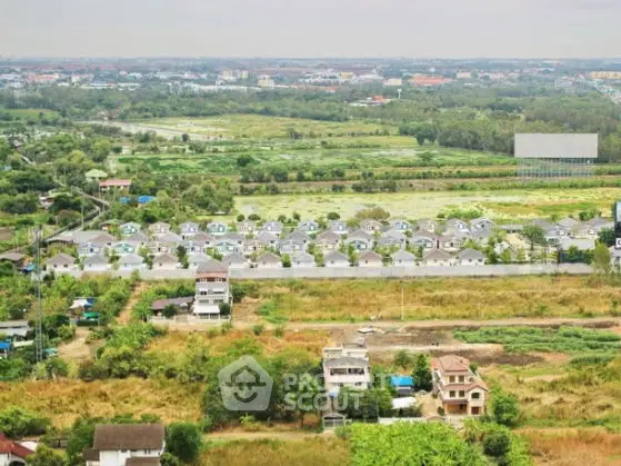 Scenic aerial view of suburban housing development with lush greenery and expansive landscape.
