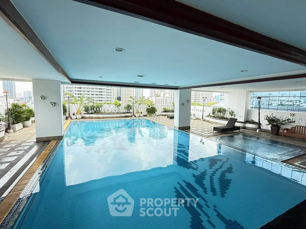 Luxurious indoor pool with city views and elegant design in high-rise building.