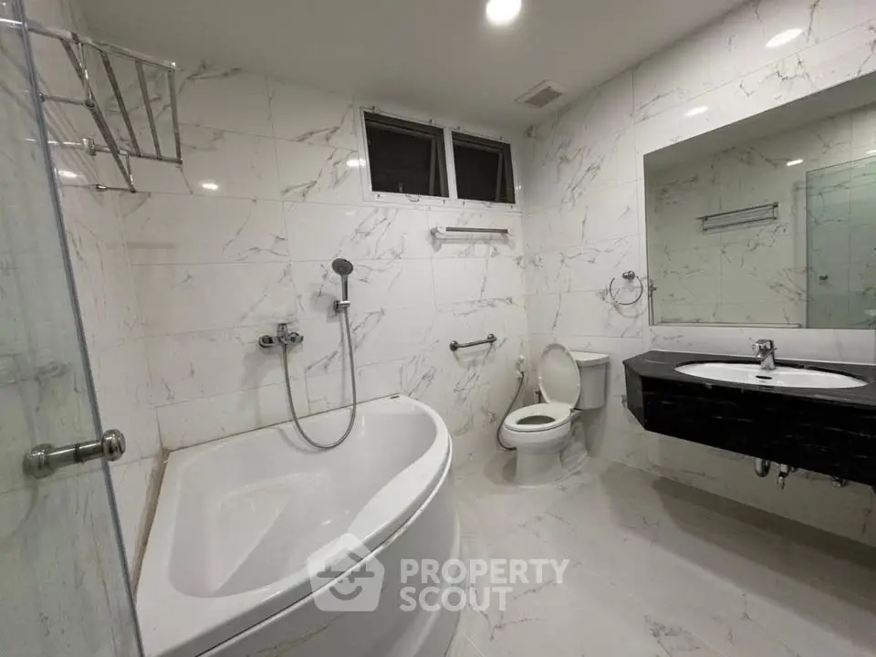 Luxurious marble bathroom with modern fixtures and spacious bathtub