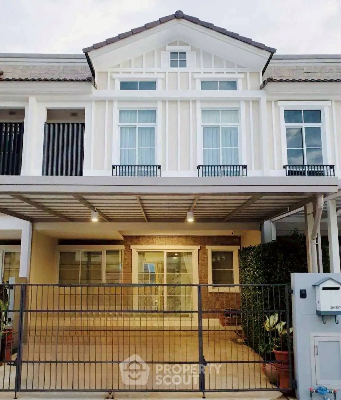 Charming two-story townhouse with modern facade and gated entrance