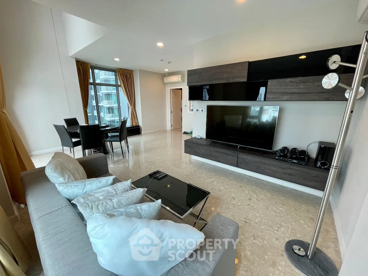 Spacious modern living room with elegant decor and large windows offering natural light.