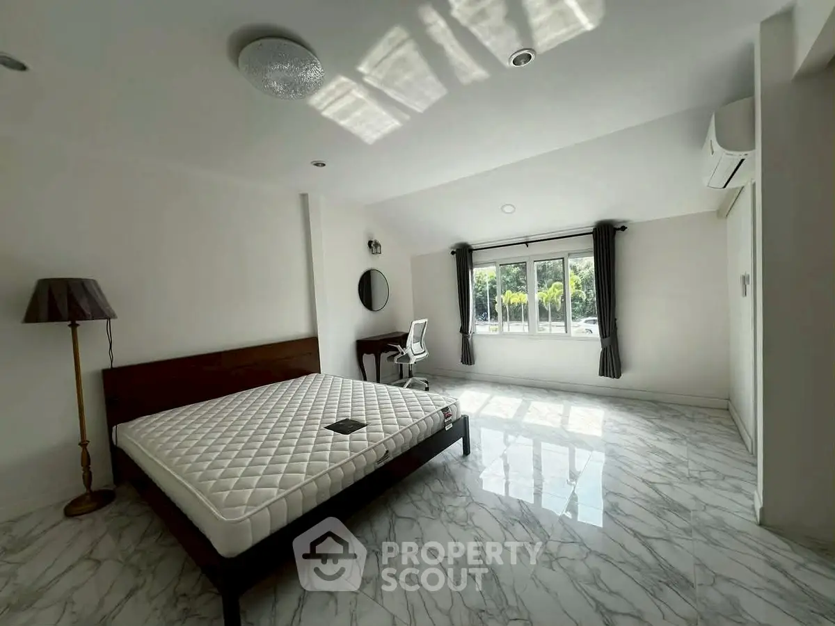 Spacious bedroom with large window and modern decor