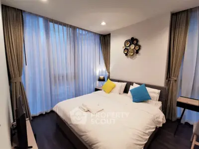 Modern bedroom with large windows and stylish decor in a high-rise apartment.