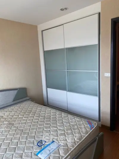 Modern bedroom with sleek wardrobe and comfortable bed in a stylish apartment.