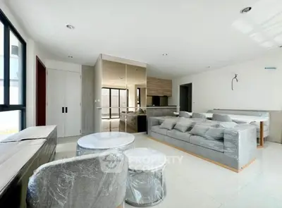 Spacious modern living room with open kitchen layout and stylish furniture.