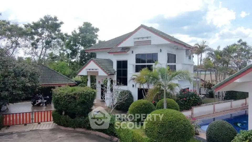 Charming two-story house with lush garden and pool, perfect for family living.