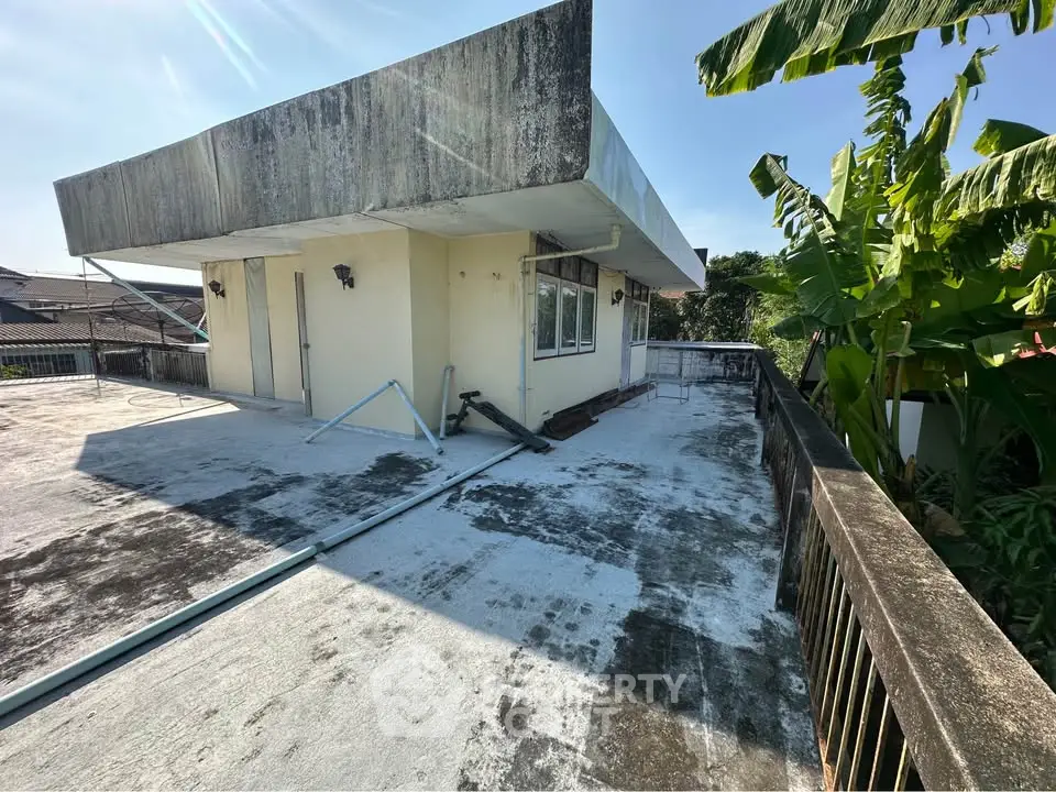 Spacious rooftop area with potential for renovation and stunning views, surrounded by lush greenery.