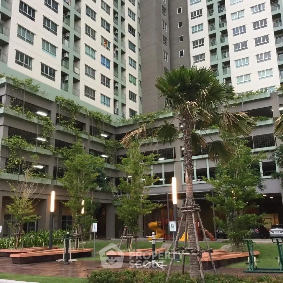 Modern residential building with lush green landscaping and tall palm trees.