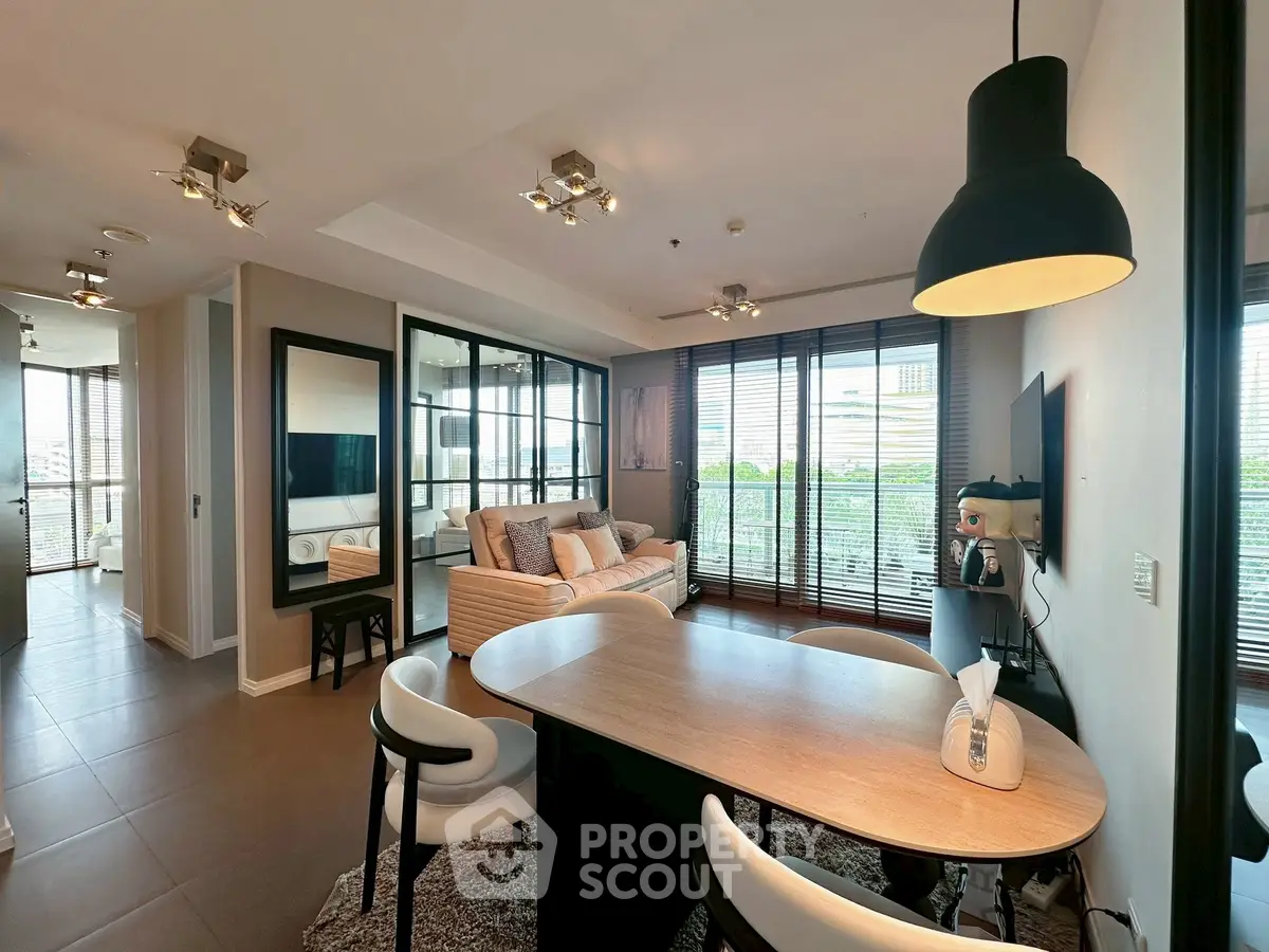 Modern open-plan living room with dining area and large windows