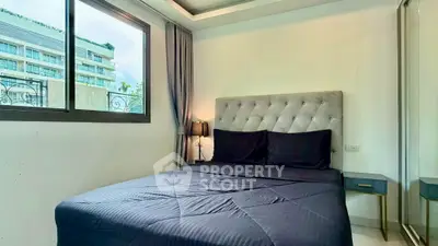 Modern bedroom with elegant decor and large window in a stylish apartment.