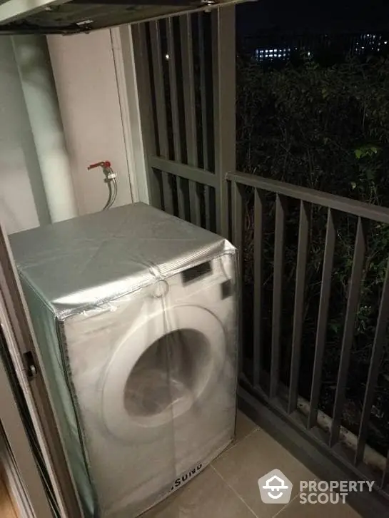 Compact balcony with modern washing machine, offering convenience and efficient use of space in a high-rise apartment.