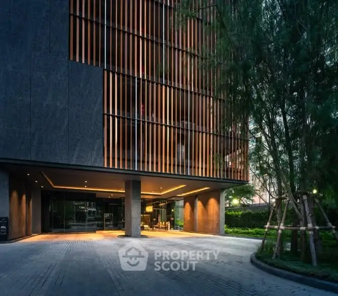 Modern building entrance with sleek design and lush greenery, perfect for urban living.