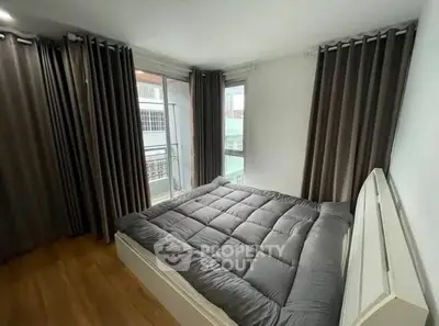 Cozy bedroom with large windows and modern decor in a stylish apartment.