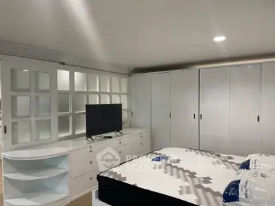 Spacious bedroom with modern furniture and ample storage space