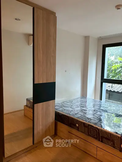 Modern bedroom with large window and wooden wardrobe