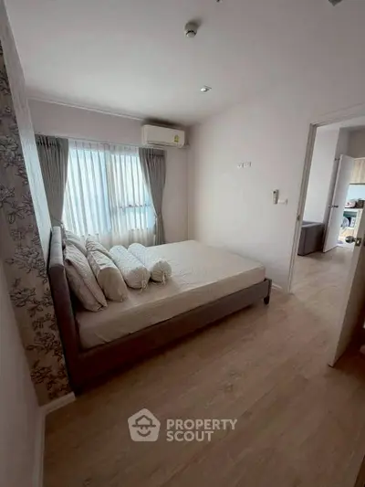 Cozy bedroom with natural light and modern decor in a stylish apartment.
