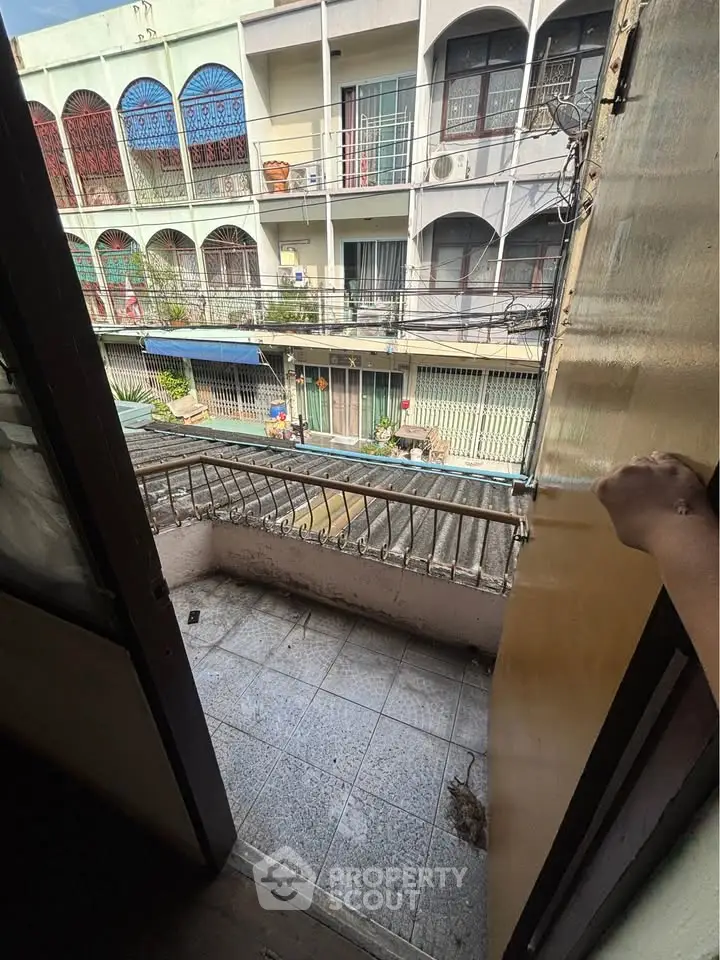 Charming urban balcony with potential, overlooking vibrant street view, ideal for city living enthusiasts.