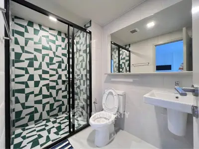 Modern bathroom with geometric tile shower and sleek fixtures