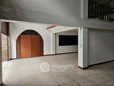 Spacious interior with unique arched wooden door and open layout, ideal for customization.