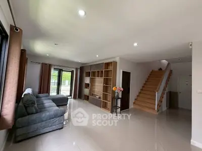 Spacious living room with modern decor and staircase in elegant home