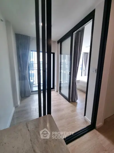 Modern apartment interior with sliding glass doors and wooden flooring, featuring a bright and airy ambiance.