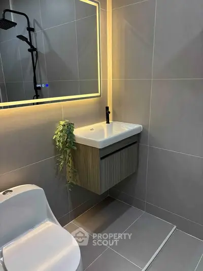 Modern bathroom with sleek fixtures and illuminated mirror