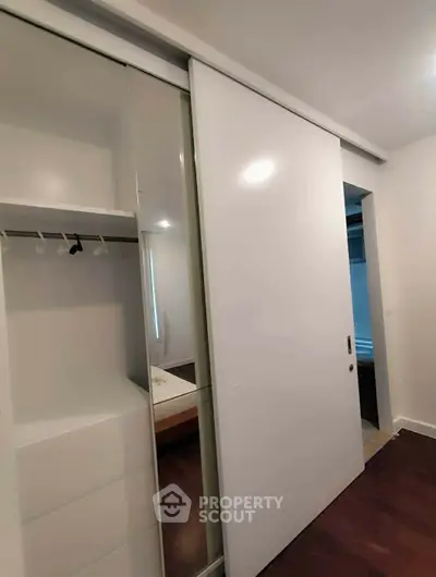Modern bedroom with sleek sliding closet doors and minimalist design.