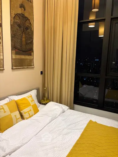 Luxurious bedroom with city view, elegant decor, and floor-to-ceiling windows in modern apartment.