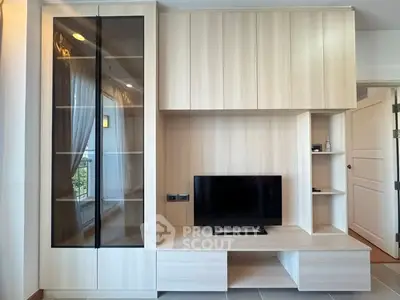 Modern living room with sleek wooden cabinetry and mounted TV
