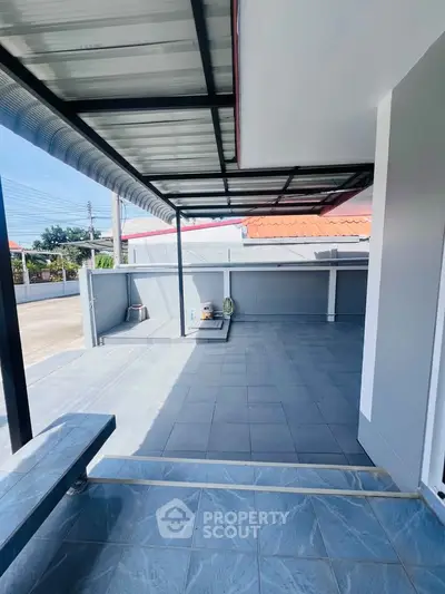 Spacious outdoor patio with tiled flooring and covered roof, perfect for relaxation and entertainment.