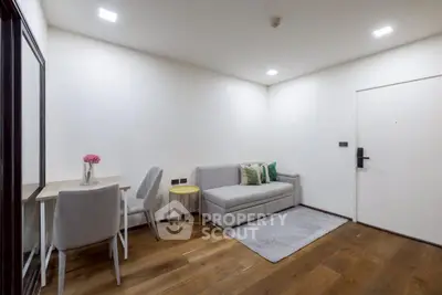 Modern living room with cozy sofa and dining area, featuring elegant wooden flooring and minimalist decor.