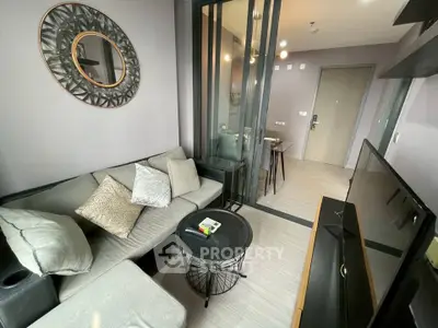 Modern living room with stylish decor and open layout, featuring a cozy sofa and sleek TV setup.