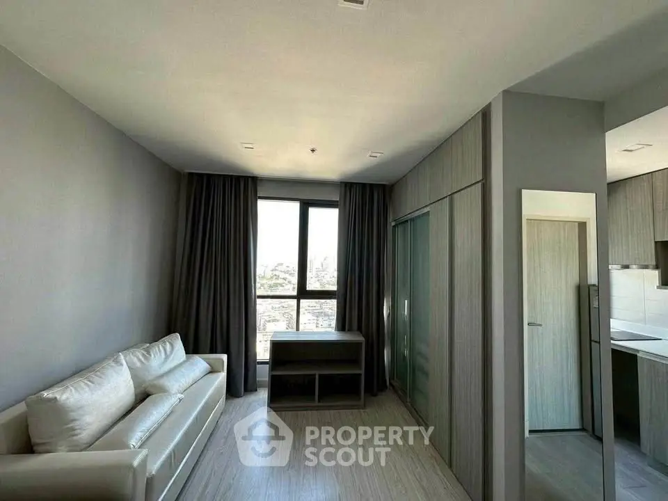Modern living room with large window and sleek furniture in a stylish apartment.