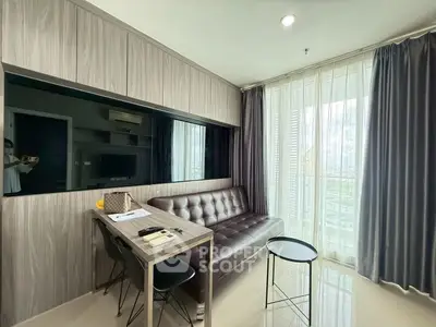 Modern living room with sleek furniture and large window offering natural light