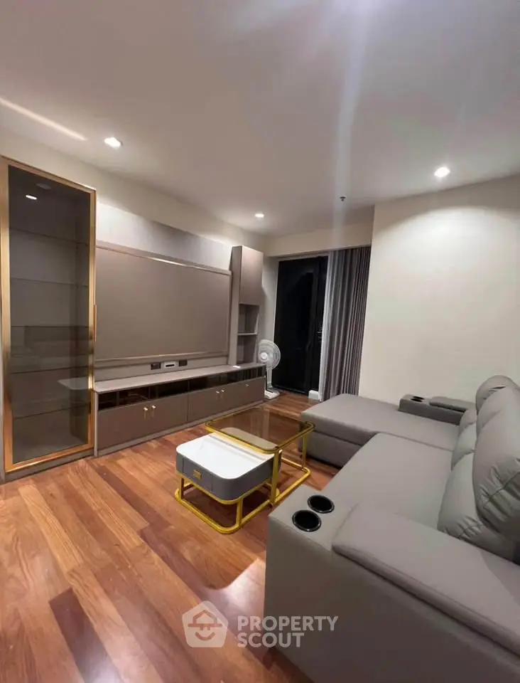 Modern living room with sleek furniture and wooden flooring, perfect for relaxation and entertainment.