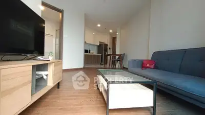 Modern living room with sleek furniture and open kitchen layout, perfect for urban living.