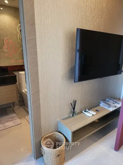Modern apartment interior with wall-mounted TV and stylish bathroom