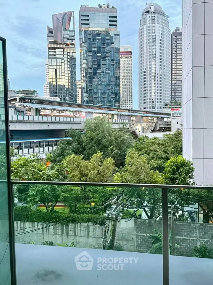 Stunning cityscape view from a modern balcony overlooking lush greenery and skyscrapers.