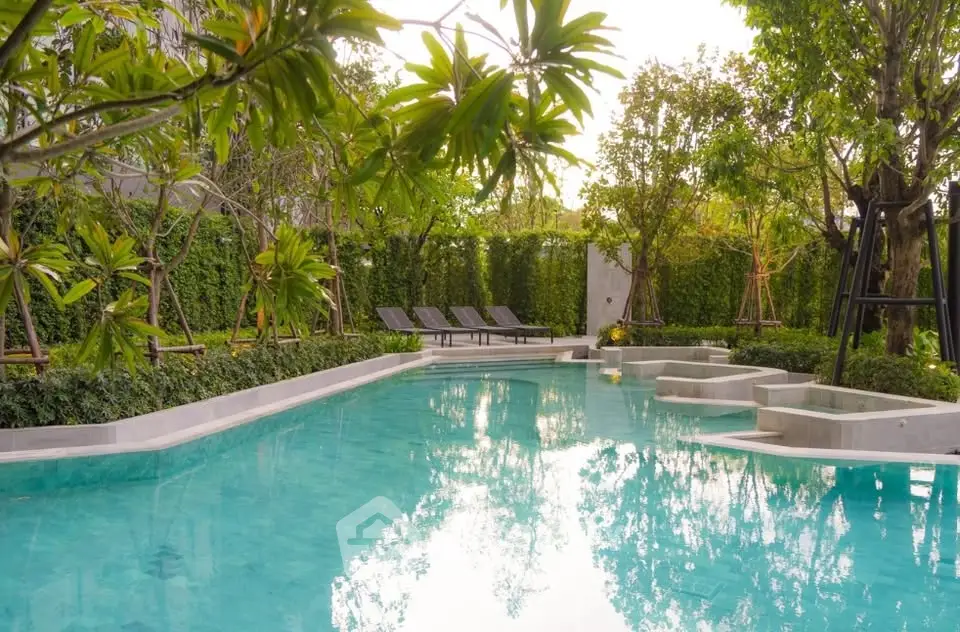 Luxurious outdoor pool surrounded by lush greenery and modern design.