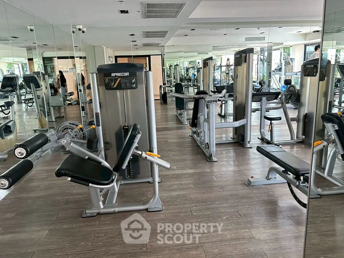 Spacious modern gym with state-of-the-art fitness equipment and mirrored walls.