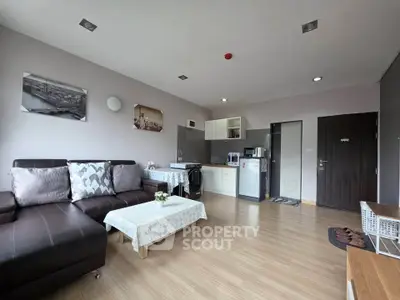 Modern living room with open kitchen, stylish decor, and cozy seating area.