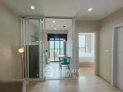 Modern apartment interior with open layout, featuring dining area and bedroom view.