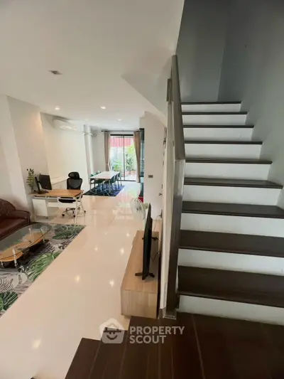 Spacious modern living room with open layout and stylish staircase, perfect for contemporary living.