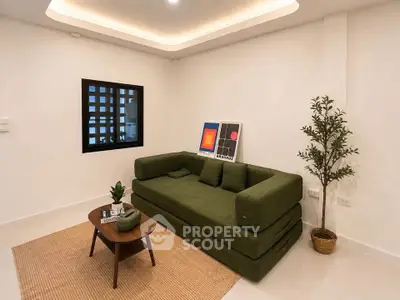 Modern living room with green sofa, stylish decor, and cozy ambiance.
