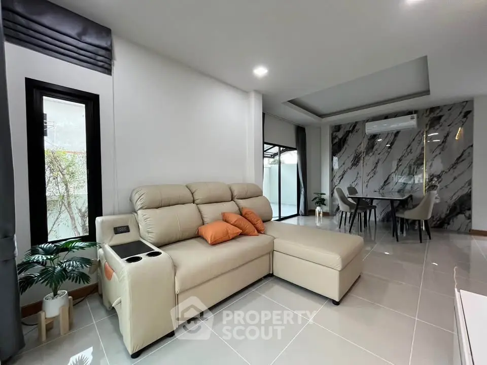 Modern living room with elegant marble accent wall and cozy beige sectional sofa.